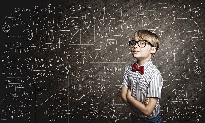 Genius boy in red glasses near blackboard with formulas