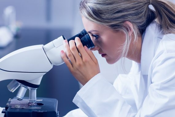 Science student looking through microscope